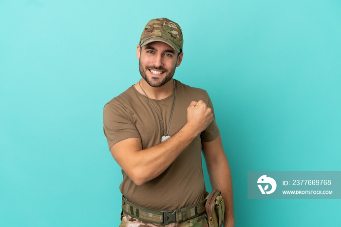 Military with dog tag over isolated on blue background celebrating a victory