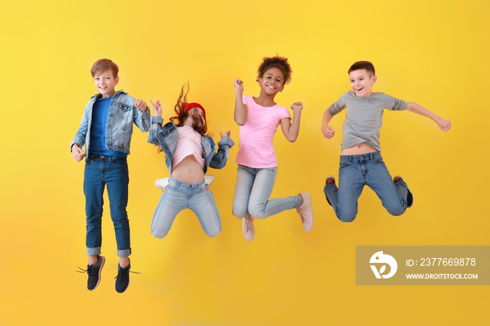 Jumping children in jeans near color wall