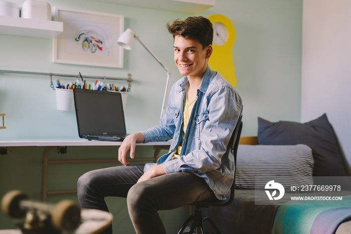 Teenage boy sitting in his room