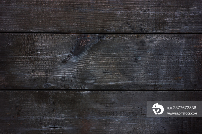 The texture of black, burnt, charred wood. View from above