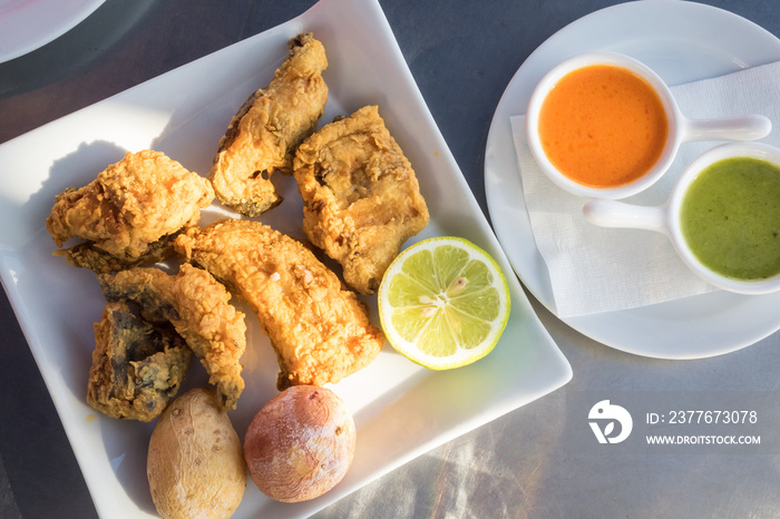 Fried moray eel with salt potato, accompanied by mojo picon and green mojo. Typical dish of the cuisine of the Canary Islands