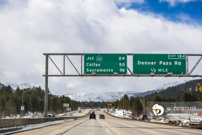 Travelling on the interstate through the Sierra mountains, close to Lake Tahoe; snow covered mountains and storm clouds; Truckee, California