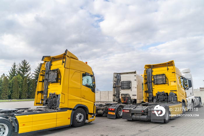 Yellow trucks company parking on summer cloudy day. Transportation industry in Europe