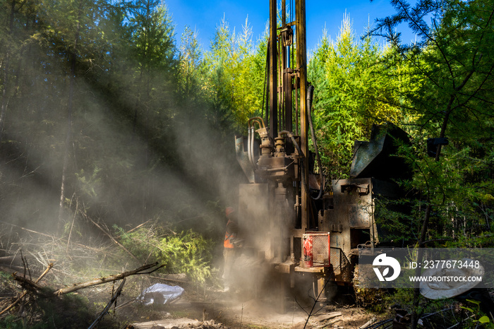 Working process of drilling a geological well. Dust when drilling borehole. drilling rig in the forest is drilling well.