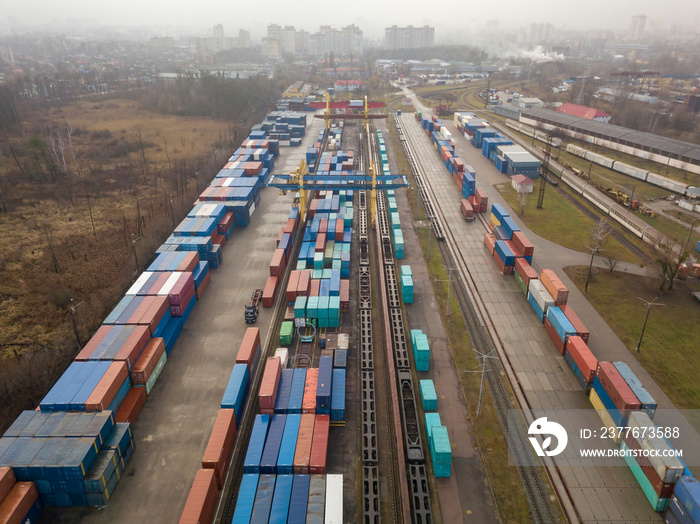 Multicolored freight containers at the railway customs. Aerial drone view.