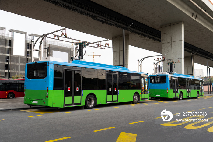 Electric buses at a stop are charging by pantograph