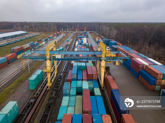 Multicolored freight containers at the railway customs. Aerial drone view.