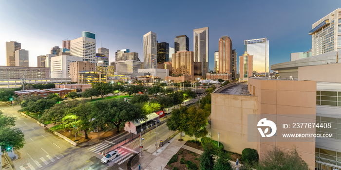 Aerial view downtown Houston illuminated at twilight with green city park and modern skylines light. The most populous city in Texas, fourth-most in United States. Architecture and travel background.