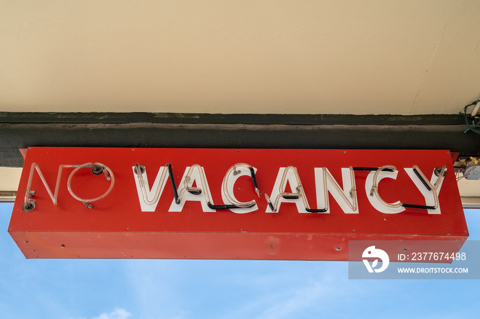 Red retro no vacancy neon sign, during daytime