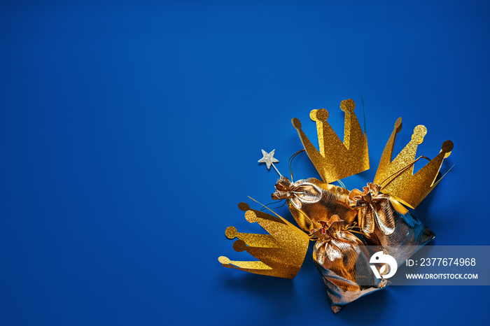 Happy Epiphany Day, Three Kings Day greeting card with three gold crowns and gifts on blue background. Concept for Dia de Reyes Magos day, three Wise Men, Epiphany Christian feast day