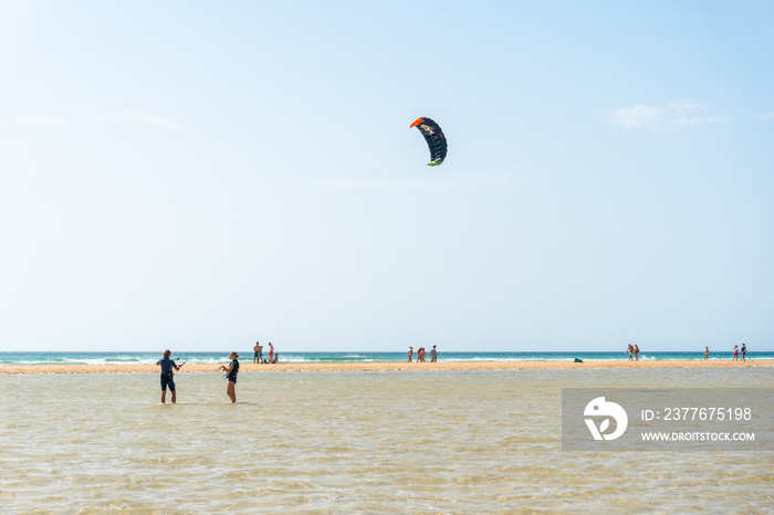 Children learning Kitesurfing or sky surfing on Sotavento beach in the south of Fuerteventura, Canary Islands. Spain