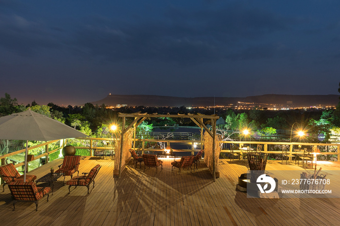 Wooden porch overlooking the Lubango lake and mountains. Night image. Angola.