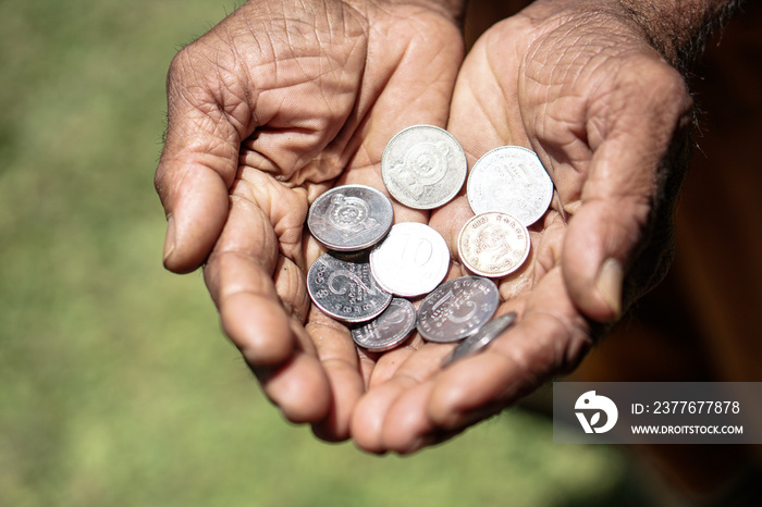 Coins in dark working hands. Beyond the poverty line in Asian countries. Subject soap bar.