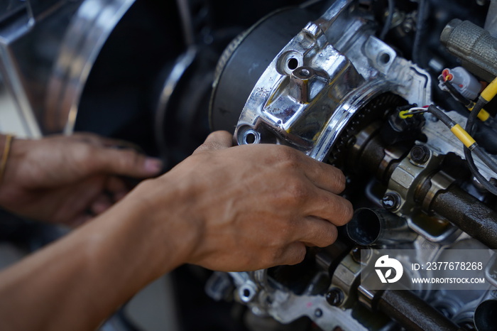 Hands working on car’s engine in a garage