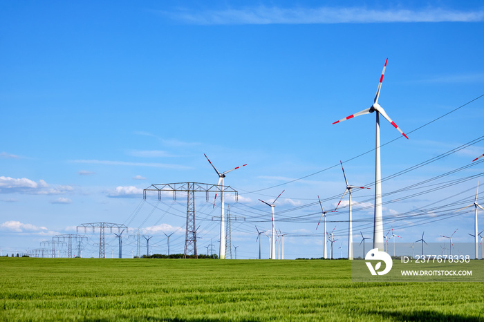 Wind turbines and power lines in a corn field in rural Germany