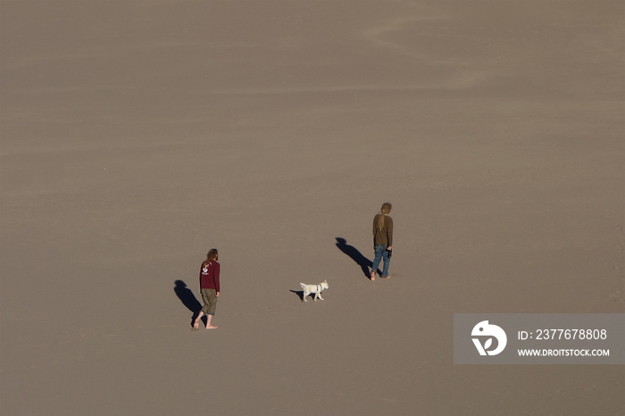 two men with a dog in the desert