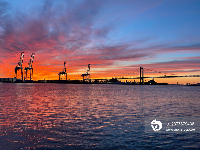 Sunset over Delaware River at Walt Whitman Bridge and Philadelphia Port