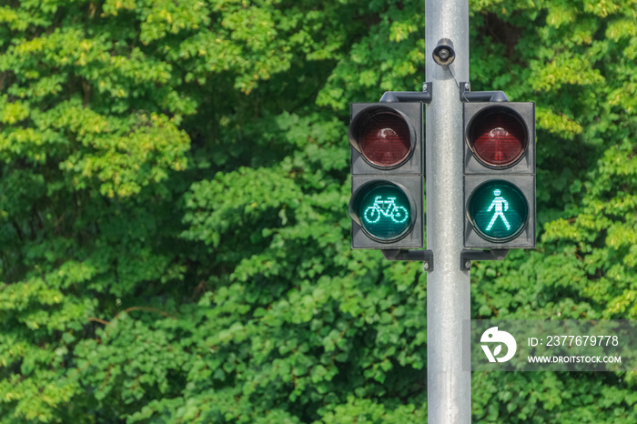 Traffic light with green little man and cyclist. Safety on the roads. Life insurance.