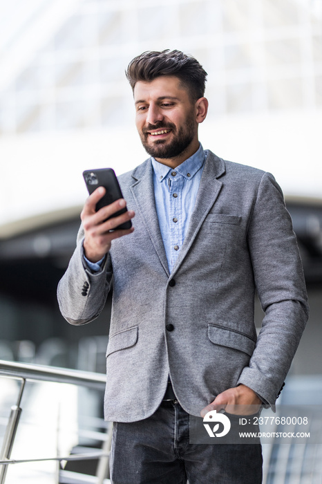 Young bearded businessman use and typing phone in office