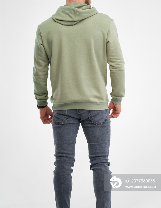 man is standing in green hoodie. isolated shot of bearded guy wears pistachio color sweatshirt with hood