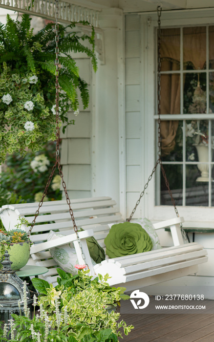 White swing on charming front porch setting on a victorian home.  Selective shallow depth of field.