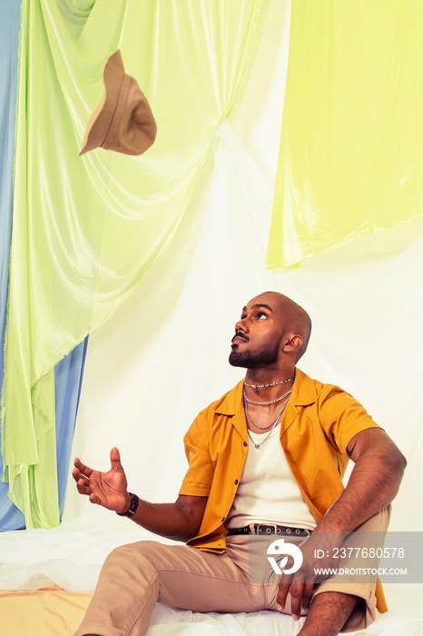 Malaysian Indian men laughing and posing together against a cloth backdrop in a studio setting, wearing fashionable clothing