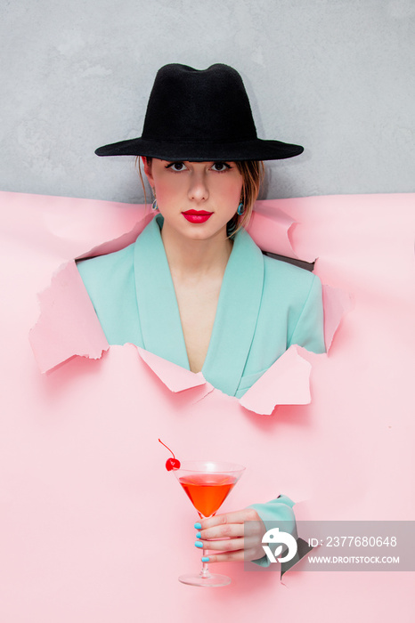 Beautiful woman in hat and blue classic jacket with martini glass