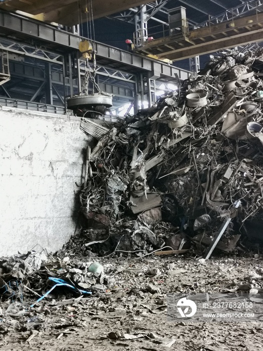 magnet crane and scrap metal at recycling center.