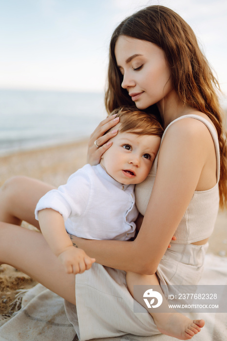 Mother with a child have fun outdoors playing games love each other. Young family with little baby boy spending time together on the beach. Family, childhood, active lifestyle concept.