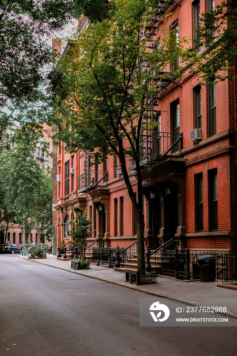 Street in Greenwich Village, Soho district. Beautiful houses and classic luxury apartment building. Entrance doors with stairs and trees. Manhattan, New York