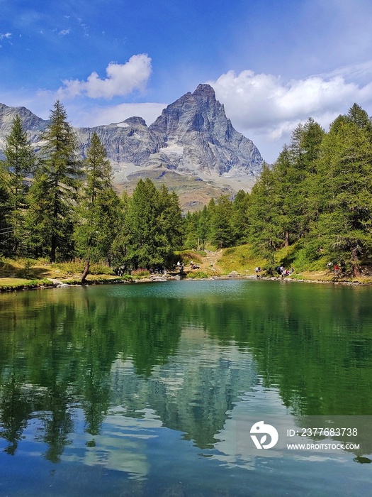 riflesso del monte cervino e del cielo nuvoloso nel lago blu