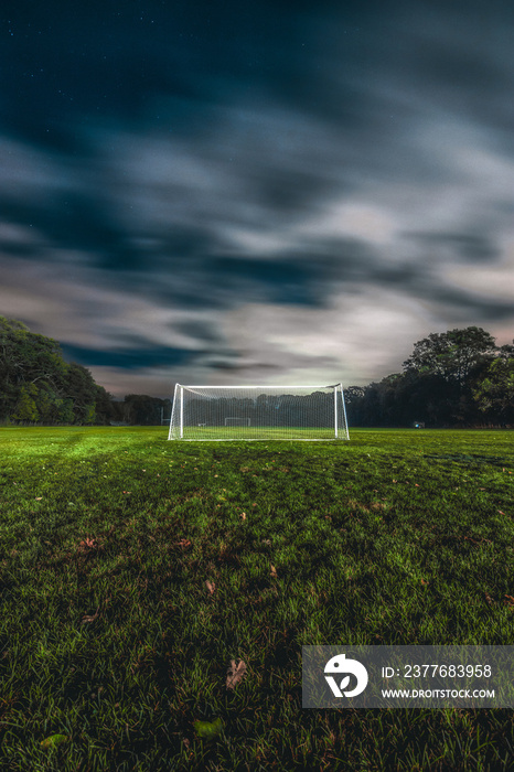 view of a football field with sky and clouds during night time