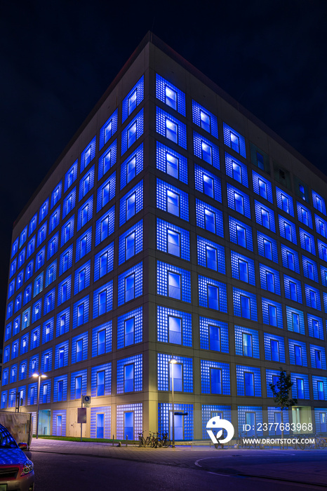 Germany, Illuminated blue facade of public library building skyscraper in downtown stuttgart city by night
