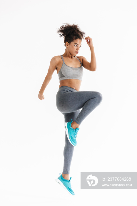 Amazing stronger sports fitness african woman make exercises isolated over white wall background.