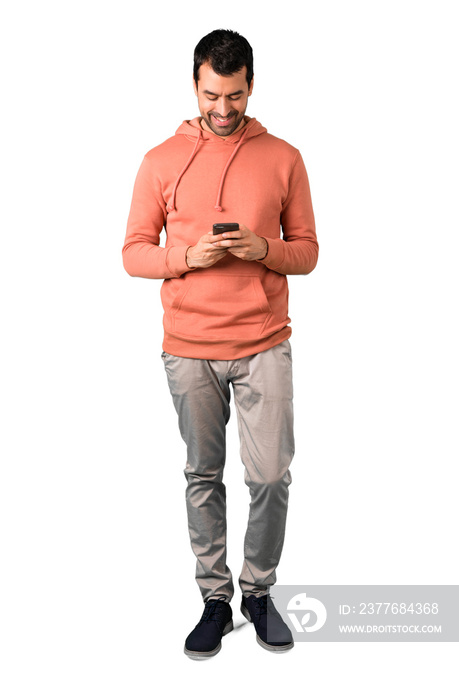 Full body of  Man in a pink sweatshirt sending a message or email with the mobile on isolated white background. Ideal for use in architectural designs