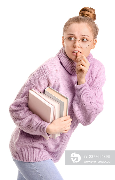 Young woman with books biting nails on white background