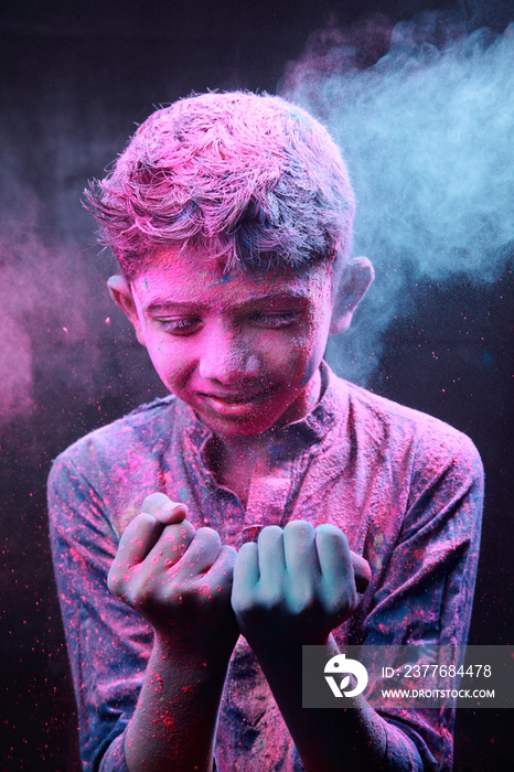 Portrait of a boy plays with colours. Concept for Indian festival Holi