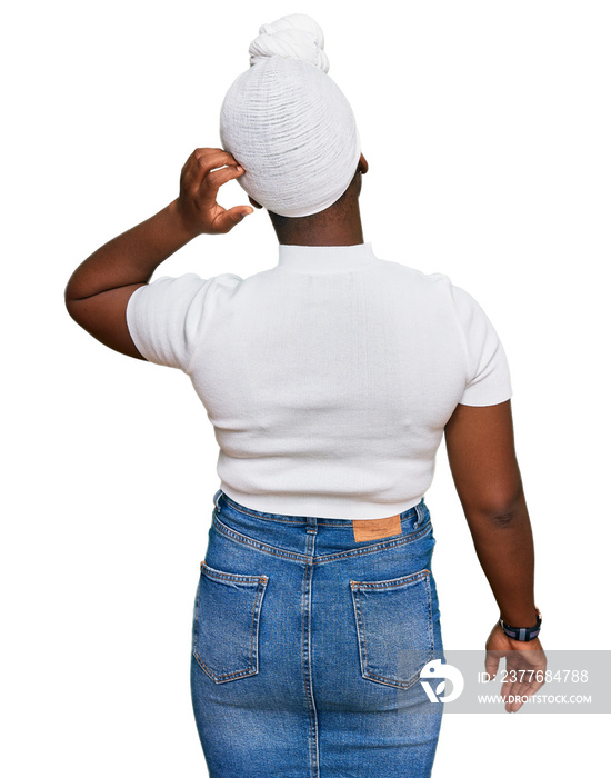 Young african woman with turban wearing hair turban over isolated background backwards thinking about doubt with hand on head