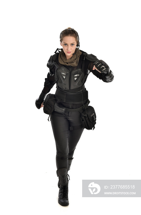 full length portrait of female  soldier wearing black  tactical armour, isolated on white studio background.