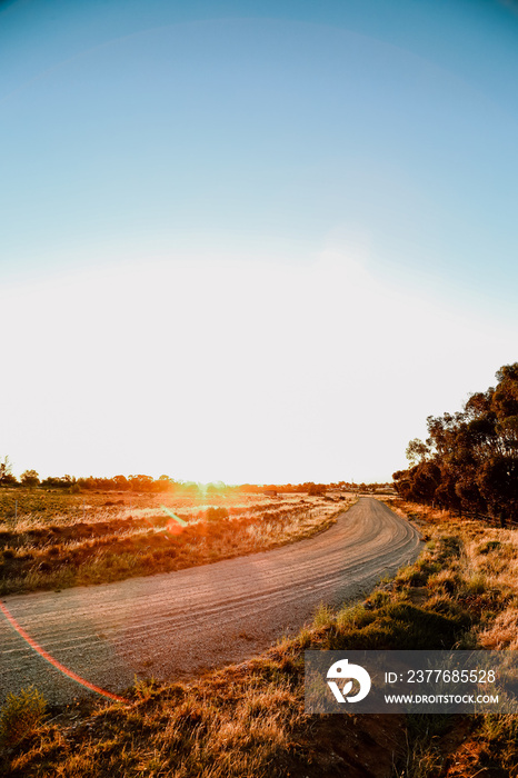 Portrait vertical image of sun setting on country road in Central Victoria, Australia. Late afternoon in Australia.