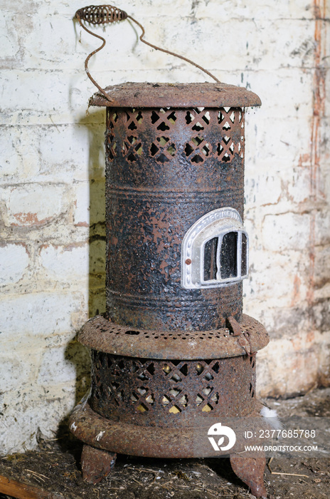 Old, antique paraffin heater, covered in rust.  Heaters like this were common in Irish homes at the start of the 20th Century.