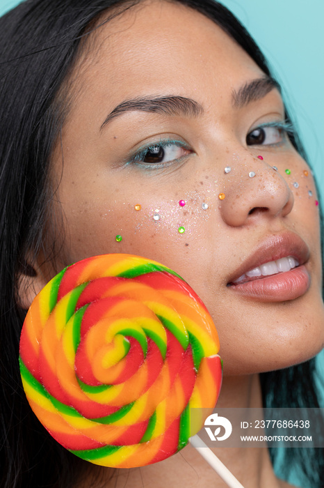 Woman holding colorful lollipop in front of face