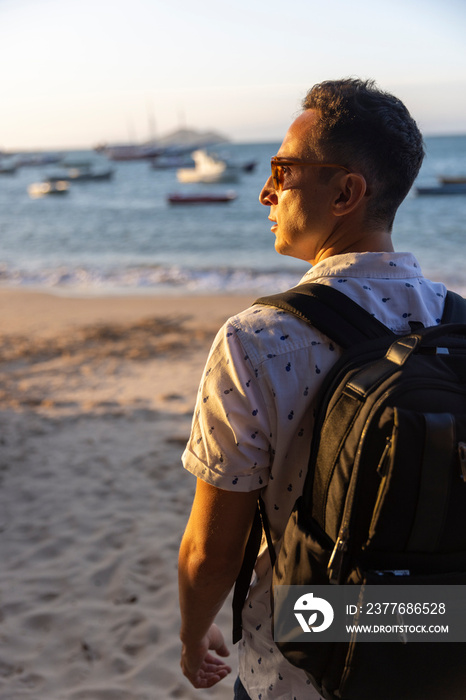 Rear view of man with backpack on beach