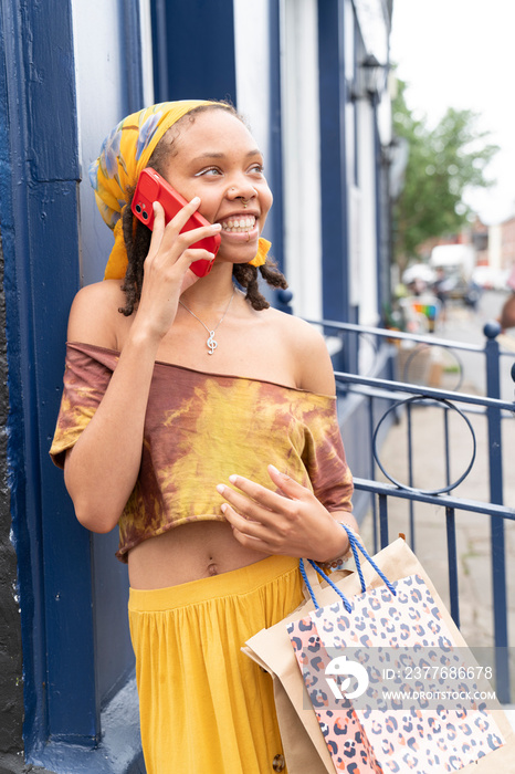 Smiling woman talking by smart phone in city