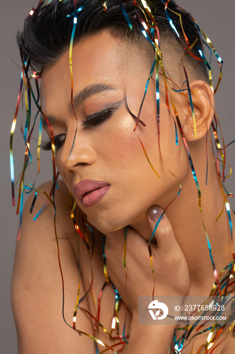 Close-up of person with shiny serpentines on head