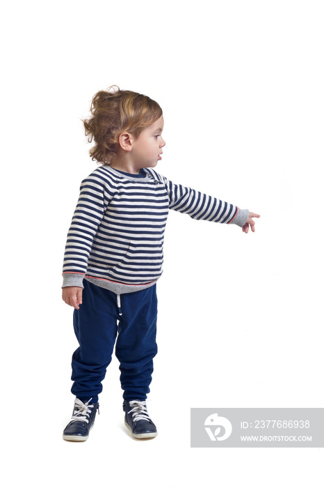 standing boy looking  and pointing finger to the side on white background