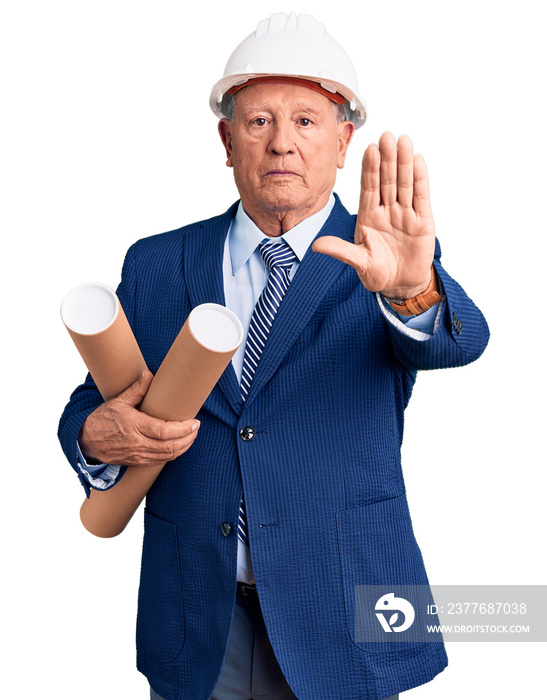 Senior handsome grey-haired man wearing architect hardhat holding blueprints with open hand doing stop sign with serious and confident expression, defense gesture