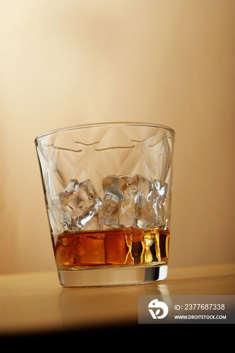 shot of rum in elegant glass on nude-colored surface