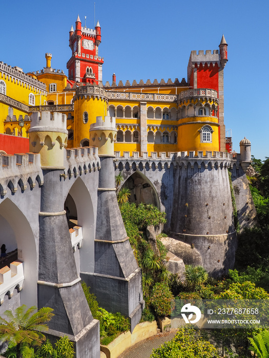 Colorful Pena Palace or Palácio da Pena on the top of a hill in the blue sky background. Exterior of national monument with a variety of architectural styles and colors. Sintra, Portugal.