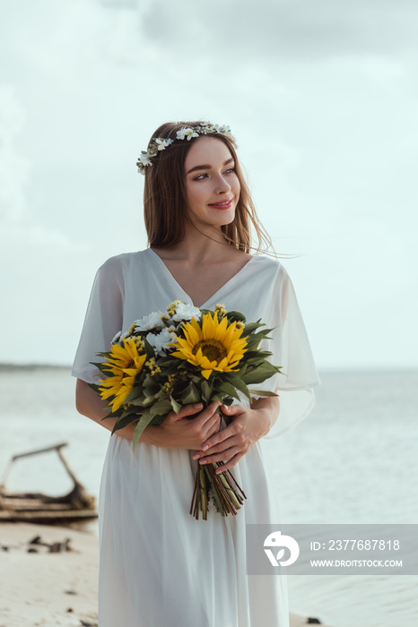 elegant smiling girl holding bouquet of sunflowers near sea